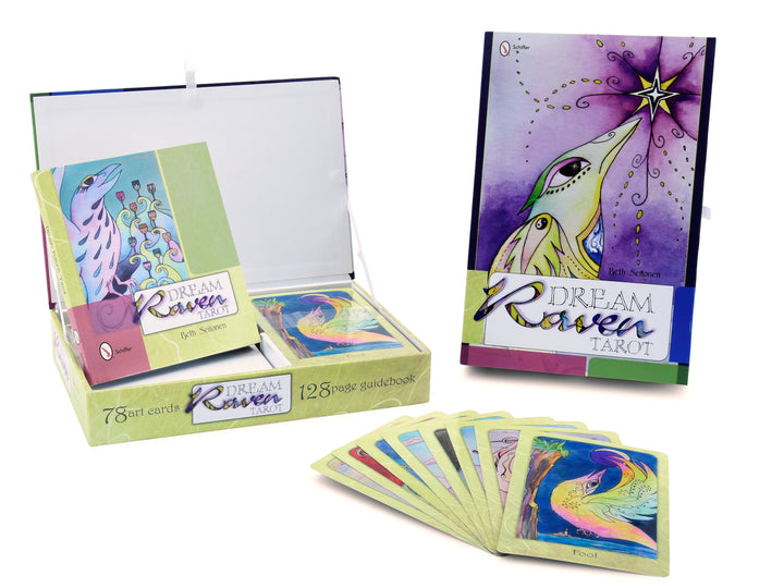 The Dream Raven Tarot by Schiffer Publishing, Ltd. includes 78 illustrated tarot cards with vibrant ravens, a decorative box, and a 128-page guidebook—shown upright alongside the open box and fanned-out cards.