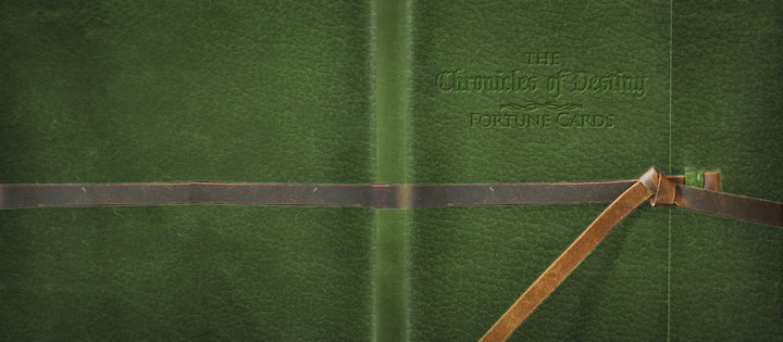 A green textured cover embossed with "The Chronicles of Destiny Fortune Cards" by Schiffer Publishing, Ltd., features two brown leather straps—one knotted at the bottom right—making it a must-have for fortune-telling card collectors.