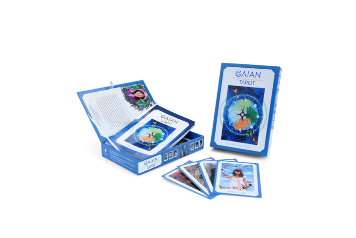 An open blue box of the Gaian Tarot by Schiffer Publishing, Ltd. reveals illustrated healing tarot cards and a booklet. Several cards are fanned out, including one featuring a woman dressed in white.