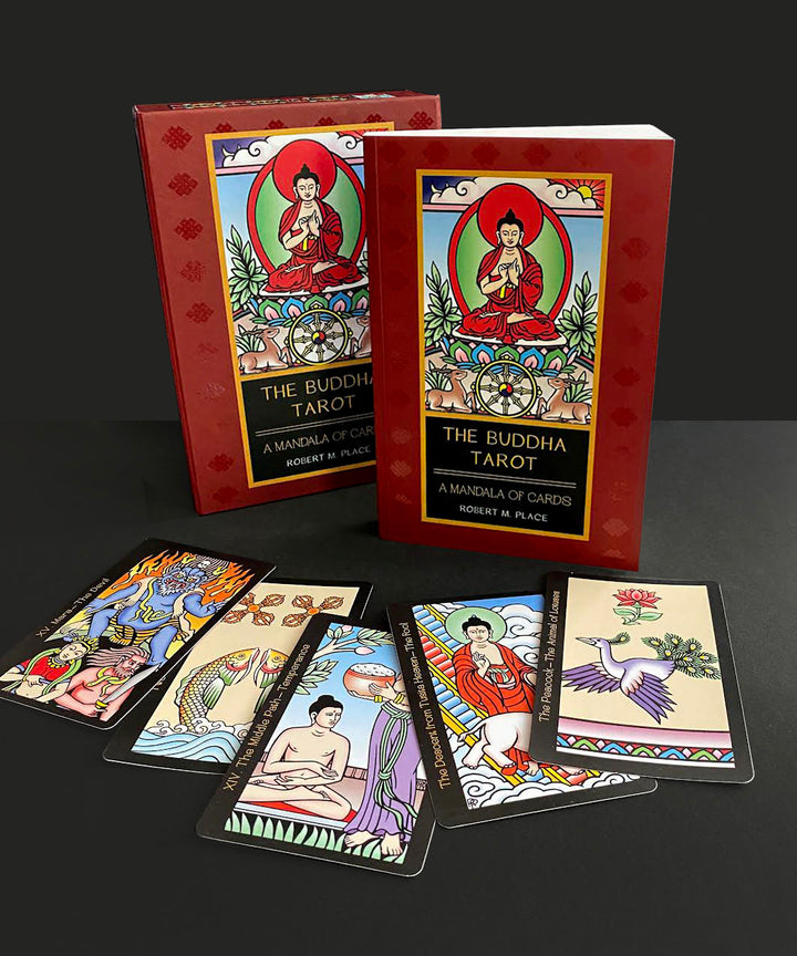 Two boxes of The Buddha Tarot by Schiffer Publishing, Ltd. are behind six vibrant Major Arcana cards with Buddhist-inspired art, all displayed in a row on a black surface against a dark background.