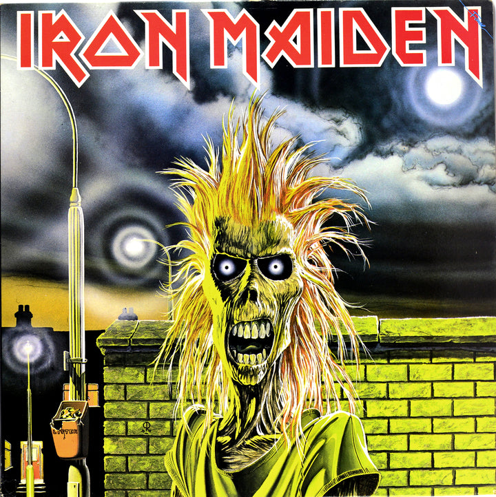 A cartoonish zombie figure with spiky yellow hair and glowing eyes stands by a brick wall under a stormy sky, channeling heavy metal album art. "The Art of Metal" by Schiffer Publishing, Ltd., appears in bold red letters at the top.