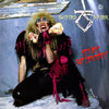 A person with long blond curly hair, heavy makeup, and a black and pink outfit holds a large bone in their mouth. Behind them, "Twisted Sister" and "Stay Hungry" are on a gray wall, as featured in The Art of Metal by Schiffer Publishing, Ltd.