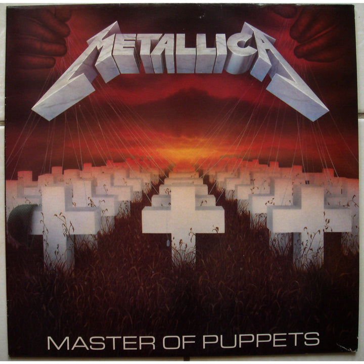 The Art of Metal by Schiffer Publishing, Ltd. showcases iconic heavy metal album artwork, like white cross-shaped graves at sunset with red hands above, and bold band logos framing the striking cover art.