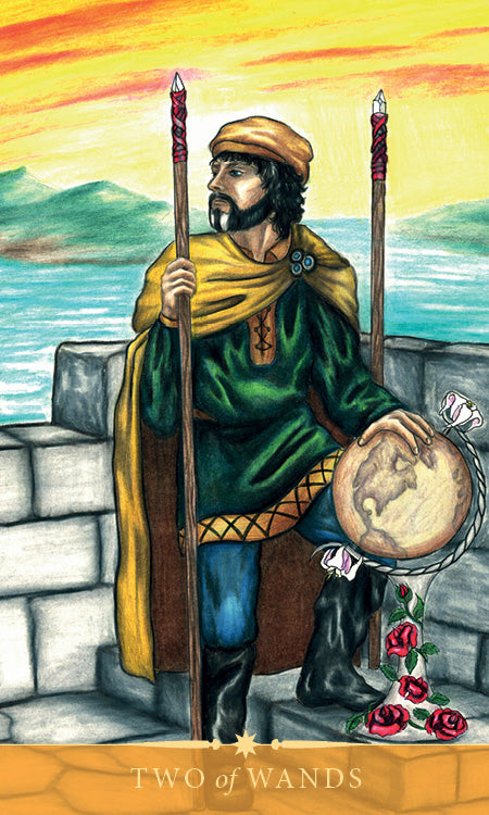 A man in medieval attire holds a globe between two wands on a stone balcony overlooking water and distant mountains beneath a yellow sky. One wand is entwined with roses. The Steele Wizard Tarot by Schiffer Publishing, Ltd. features the Two of Wands card.