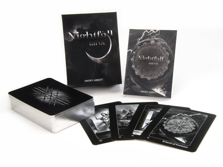 The Nightfall Tarot by Schiffer Publishing, Ltd. is displayed with its 78 illustrated cards inspired by Rider-Waite-Smith, a closed box, and a guidebook. Several cards, such as Wheel of Fortune, are fanned out to show their black-and-white artwork.