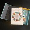 An open box set of The Time Changer's Tarot by Schiffer Publishing, Ltd. reveals the included book and modern tarot deck against a black background.