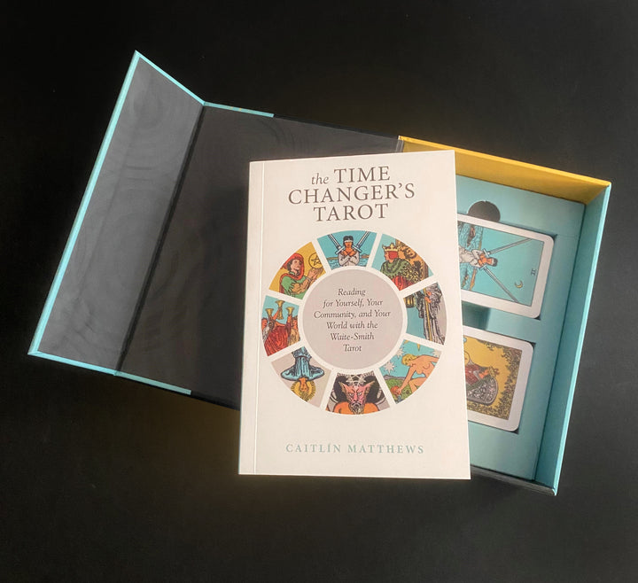 An open box set of The Time Changer's Tarot by Schiffer Publishing, Ltd. reveals the included book and modern tarot deck against a black background.