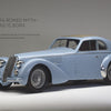 A light blue vintage Alfa Romeo coupe with wire wheels is showcased in a studio. Text: "Alfa Romeo—a legend is born," celebrating Italian automotive history. Product by Schiffer Publishing, Ltd.