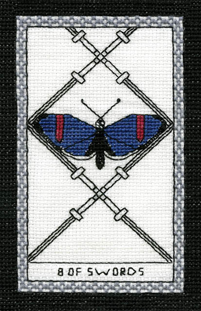 The Butterfly Wisdom Tarot by Schiffer Publishing, Ltd. features an embroidered 8 of Swords card: a blue butterfly with red markings amid eight crossing swords on white, symbolizing transformative healing, bordered in gray and black.