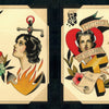The Cut-Ups 2 by Schiffer Publishing, Ltd. features hand-painted tattoo flash art: a snake with candle, two women, heart with flames, rose with dagger, skull with crown and sword, banners, and floral details.