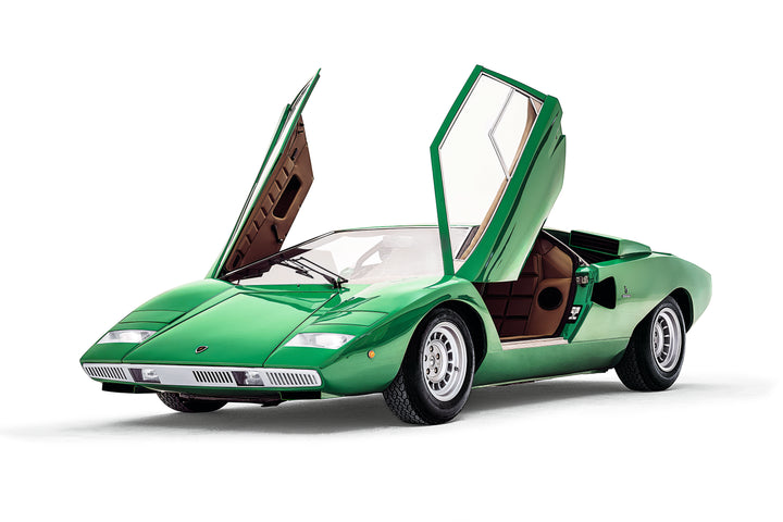 A green Automobili Lamborghini by Schiffer Publishing, Ltd. luxury sports car with both scissor doors open, viewed from the front left on a white background.