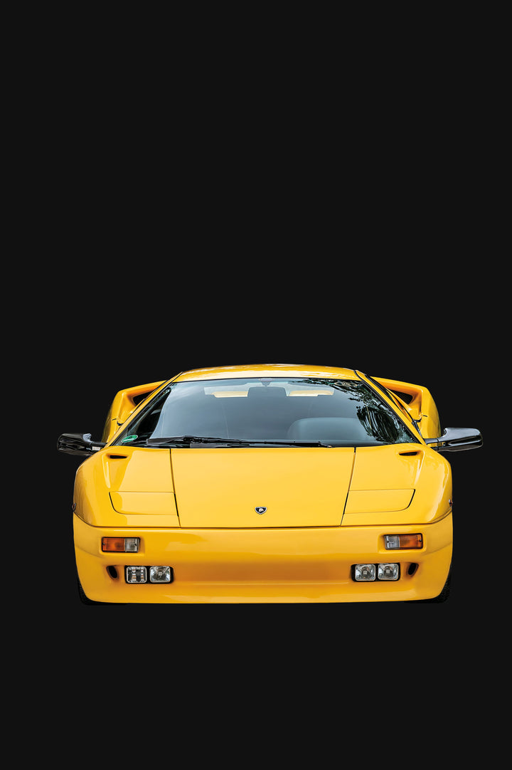 A bright yellow Automobili Lamborghini Special Edition by Schiffer Publishing, Ltd. is shown from the front against a solid black background, featuring a sleek, low design with pop-up headlights and aerodynamic side mirrors.