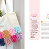 The Handmade Happiness Yarn Crafts tote bag by Schiffer Publishing, Ltd. hangs on a white wall, decorated with colorful yarn flowers and filled with yellow and pink blooms. Instructions and text appear to the right.