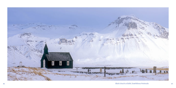 A small black wooden church from the Schiffer Publishing, Ltd. Iceland book sits in a snow-covered Icelandic landscape in front of large, frost-dusted mountains.