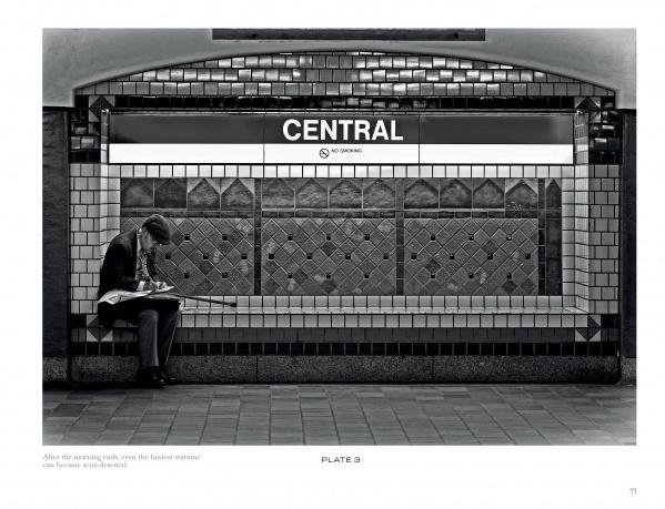 A person sits alone on a bench at Central station, reading a newspaper—a quiet moment featured in "Boston Below" by Schiffer Publishing, Ltd., capturing classic T-riders on the Boston MBTA subway amid patterned tiles and signs.