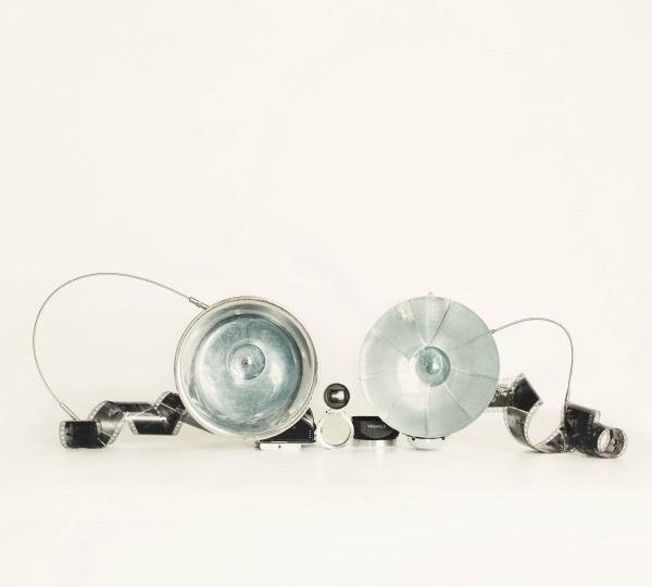 Schiffer Publishing, Ltd.'s "No Lumps, Thank You." is displayed side by side with large silver reflectors and black cameras connected by winding cords, set against a plain white background.