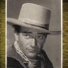 Black-and-white portrait of a man in a cowboy hat and scarf, with “John Wayne 1907–1979.” This 1940 autographed photo, valued at $700–$900, appears in Western Movie Photographs and Autographs by Schiffer Publishing, Ltd.