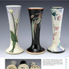 Three tall, slender vases with flared tops from Santa Barbara Ceramic Design by Schiffer Publishing, Ltd. feature unique ceramic art: white calla lilies, green foliage on black, and a multicolor abstract floral pattern.