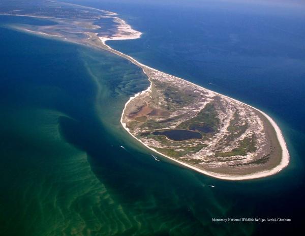 Stunning aerial view of Monomoy National Wildlife Refuge, as featured in "Cape Cod & the Islands Reflections" by Schiffer Publishing, Ltd.—crescent-shaped shores, vivid waters, and lush landscapes capture Cape Cod’s natural beauty.