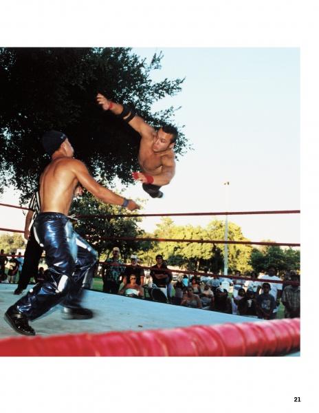 A wrestler soars toward an opponent in an outdoor ring as a referee and crowd watch under sunlit trees—a thrilling scene from Hard Boys and Bad Girls by Schiffer Publishing, Ltd., inspiring aspiring wrestlers everywhere.