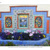 A decorative fountain by Catalina Island Pottery and Tile (Schiffer Publishing, Ltd.) showcases vibrant blue, red, and patterned floral and landscape tiles, repurposed as a planter blooming with colorful flowers.