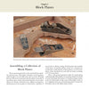 Three wooden hand planes and one metal block plane sit on a workbench above an open copy of "Hand Planes in the Modern Shop" by Schiffer Publishing, Ltd.; the wooden planes differ in size and style.