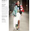 A model walks on a wooden floor in a vibrant outfit inspired by emerging European trends, as featured in "Europe: Rising Fashion Designers" by Schiffer Publishing, Ltd.