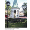 On the Civil War Walking Tour of Savannah by Schiffer Publishing, Ltd., see a historic white bell tower with a green steeple, set in a fenced area near battlefields, beside a street lamp, and surrounded by trees, cars, and red-brick buildings.