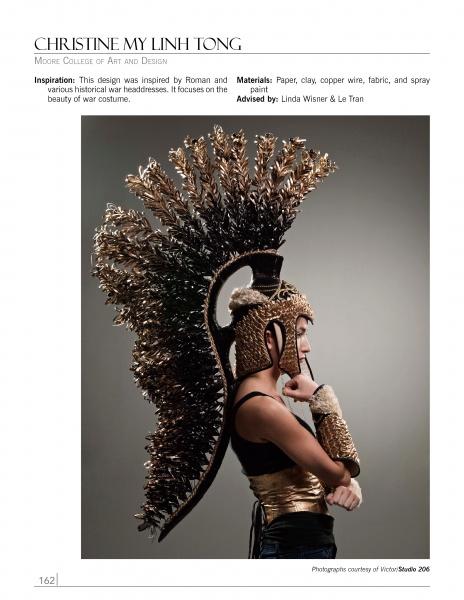 A person wears an elaborate gold and black headpiece resembling a Roman helmet with feather-like extensions, showcasing bold fashion inspired by history—featured in "Emerging Fashion Designers 2" by Schiffer Publishing, Ltd.