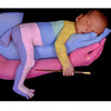 In a scene from Painted Alive by Schiffer Publishing, Ltd., a newborn sleeps on pastel-painted adult hands, its body partly painted and holding a paintbrush—a tender moment of contemporary art and bodypainting set against a black background.