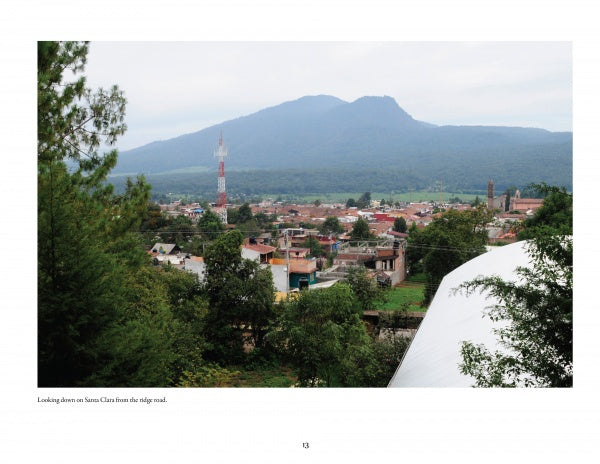 View of Santa Clara del Cobre, famed for hammered copper vessels featured in "Mexican Arts Series: Hammered Copper" by Schiffer Publishing, Ltd., with buildings, trees, a red and white radio tower, and a forested mountain under a cloudy sky.