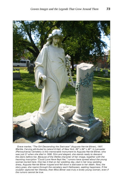 A white marble statue stands by an old gravestone amid grass and trees, evoking the atmosphere found in Amish Folk Tales & Other Stories of the Pennsylvania Dutch from Schiffer Publishing, Ltd.