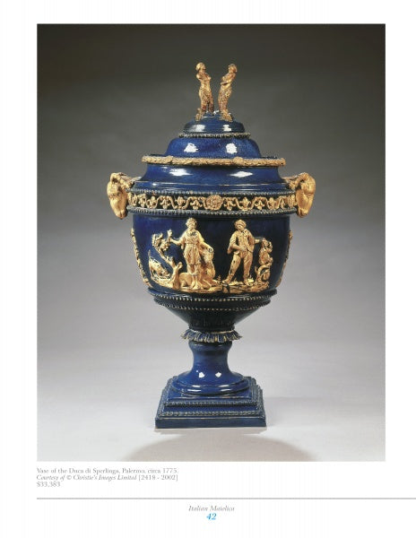 The Mediterranean Maiolica by Schiffer Publishing, Ltd. is a blue and gold lusterware vase with a lid, featuring sculpted classical figures, intricate patterns, two gold figurines on top, and a pedestal base prized by collectors.