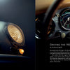 On the left page, Air & Water by Schiffer Publishing, Ltd. shows a close-up of a vintage Porsche’s front grille and headlight; on the right, the car’s dashboard gauges and an article about driving rare Porsches appear on a black background.
