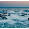 Experience serene Japanese beauty with "Japan" by Schiffer Publishing, Ltd.—a photography book featuring a torii gate rising from rocky outcrops amid gentle waves and a pastel sky, capturing the essence of dawn or dusk.